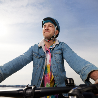 Tim, an actual BEQVEZTM (fidanacogene elaparvovec- dzkt) patient, on a bicycle with the words, "Tim, who received the BEQVEZ infusion in 2021" and "Tim participated in the BEQVEZ clinical study."