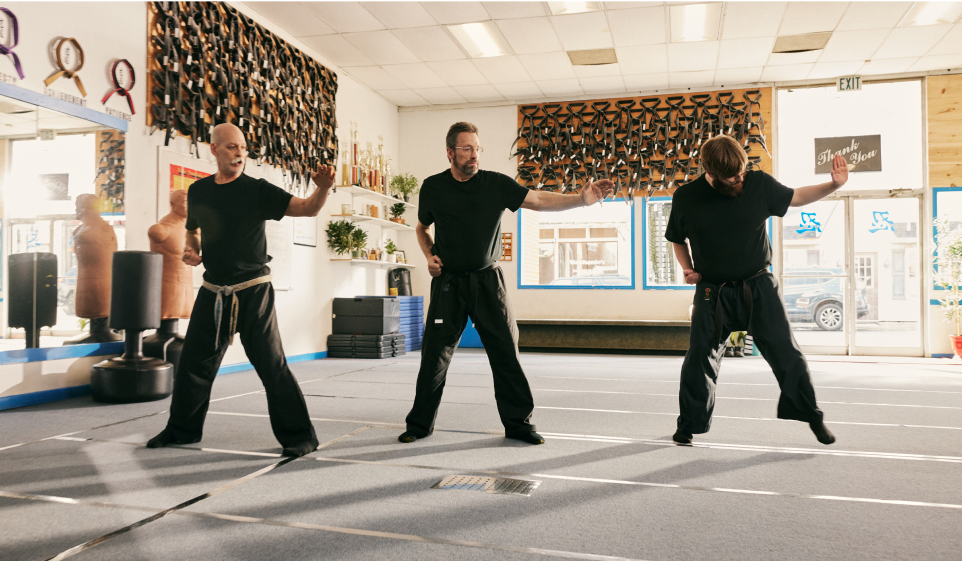 Three men engaging in martial arts